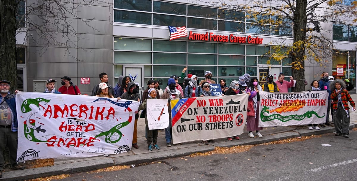 A group of protestors in front of the Armed Forces career center holding signs opposing US intervention in Venezuela